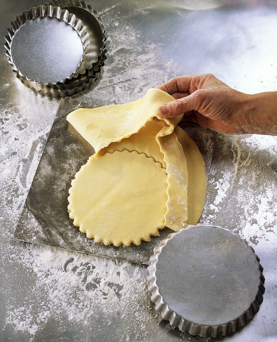 Using a baking tin to cut out pastry for tarts