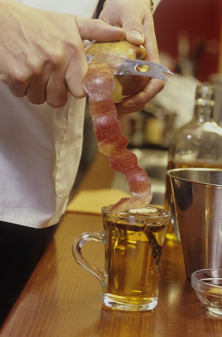 Putting apple peel into a glass of punch