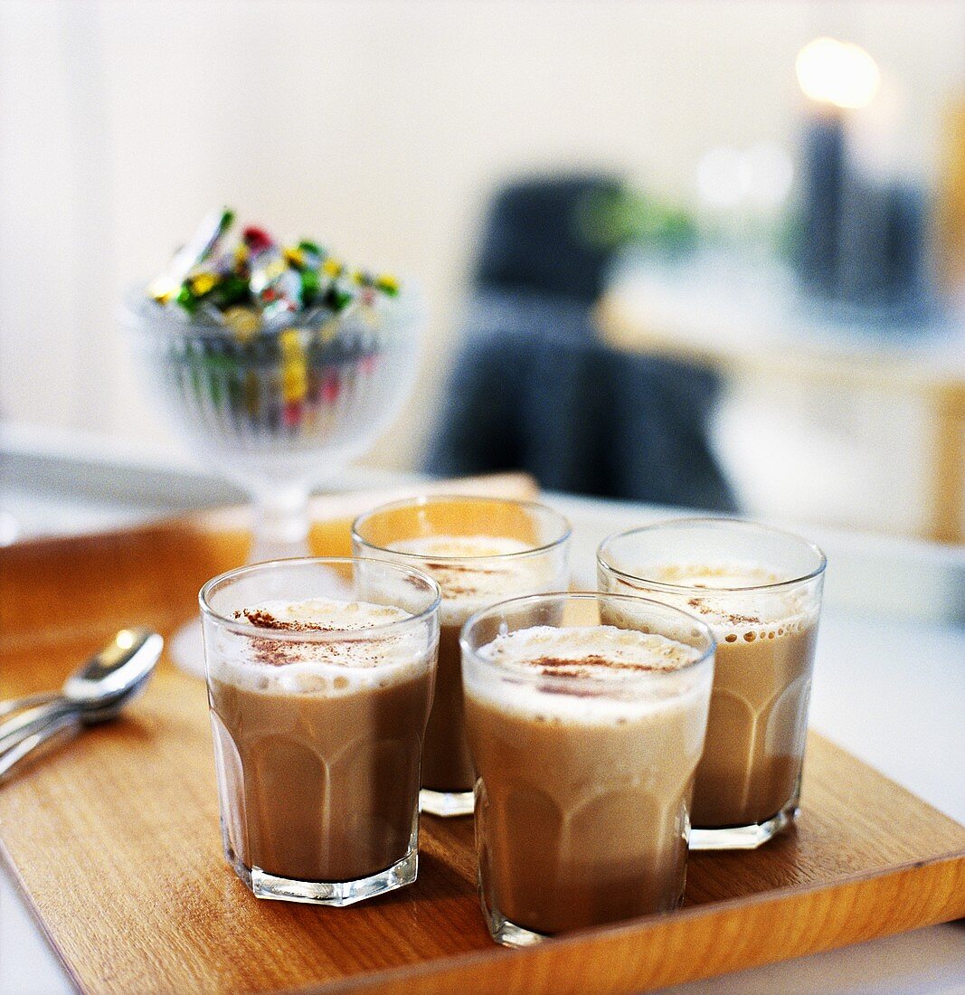 Milky coffee in glasses on tray