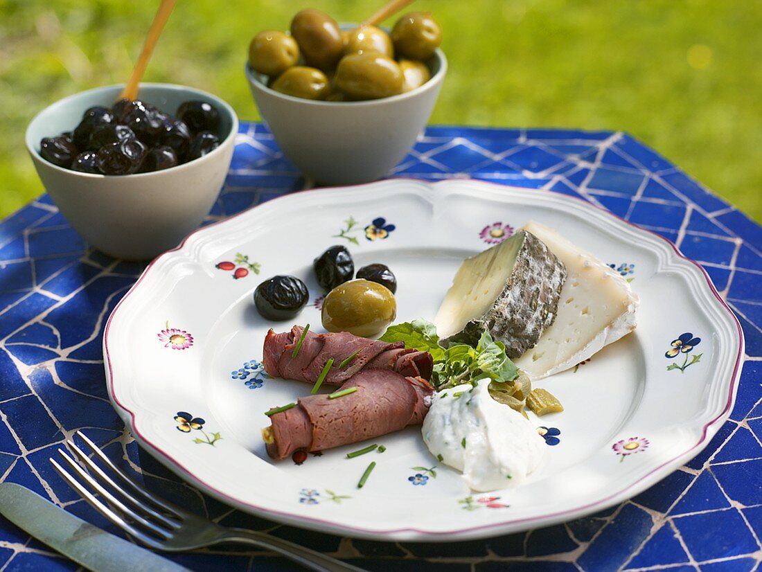 Appetiser plate with roast beef, cheese and olives