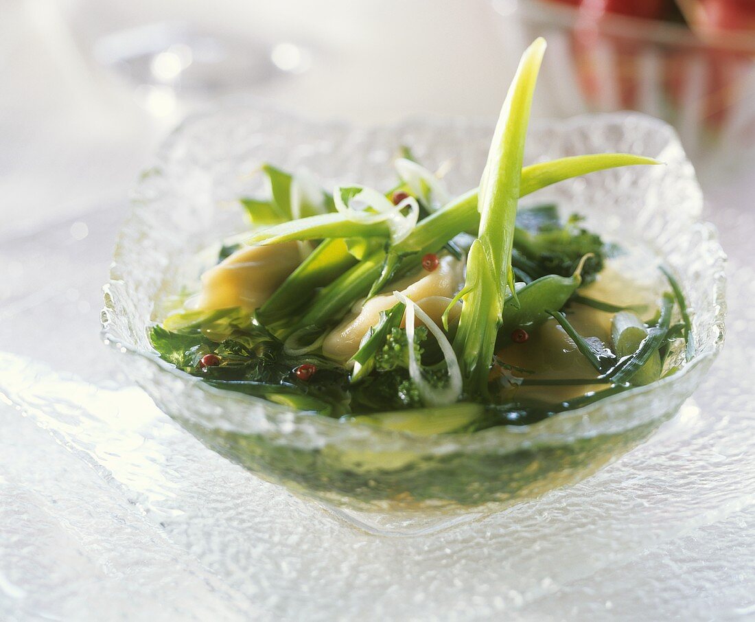Suppe mit Ravioli und grünem Gemüse