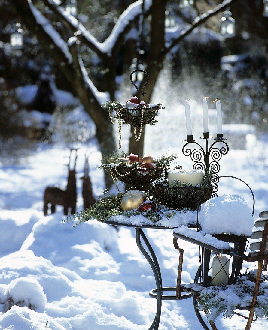 Weihnachtlich dekorierter Tisch in verschneitem Garten