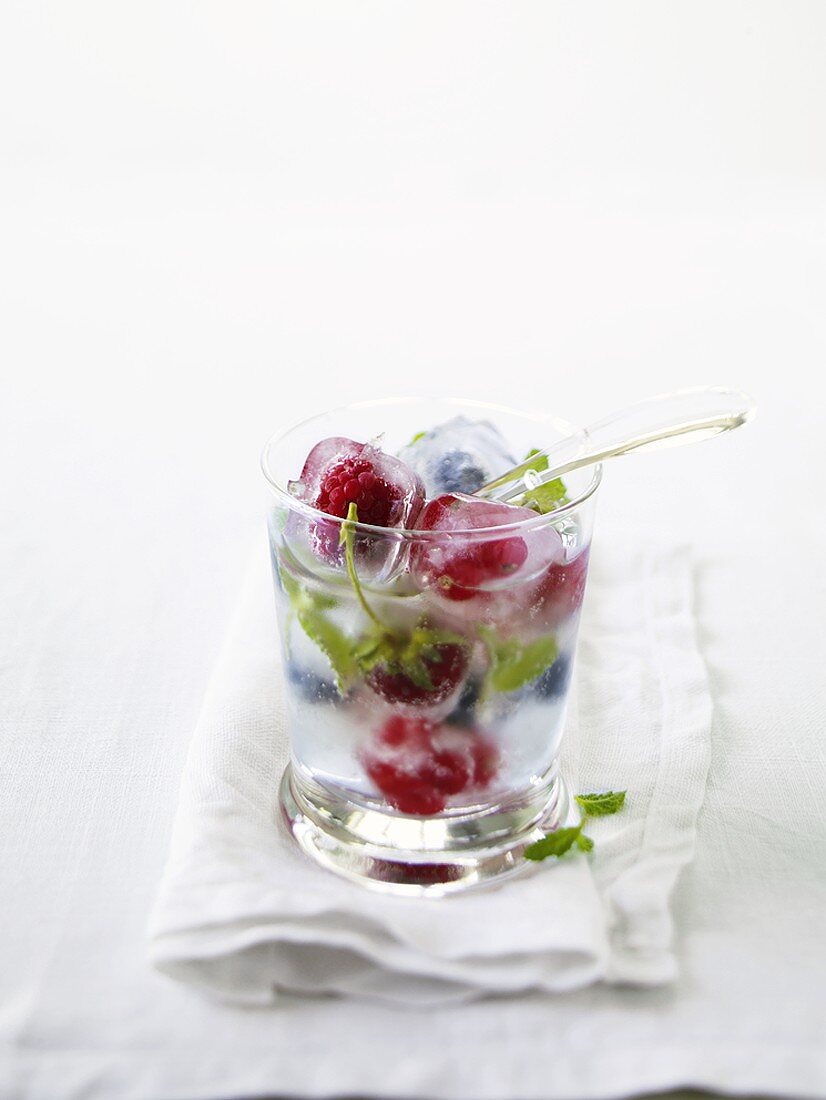 Summer punch: Prosecco with berry ice cubes in glass