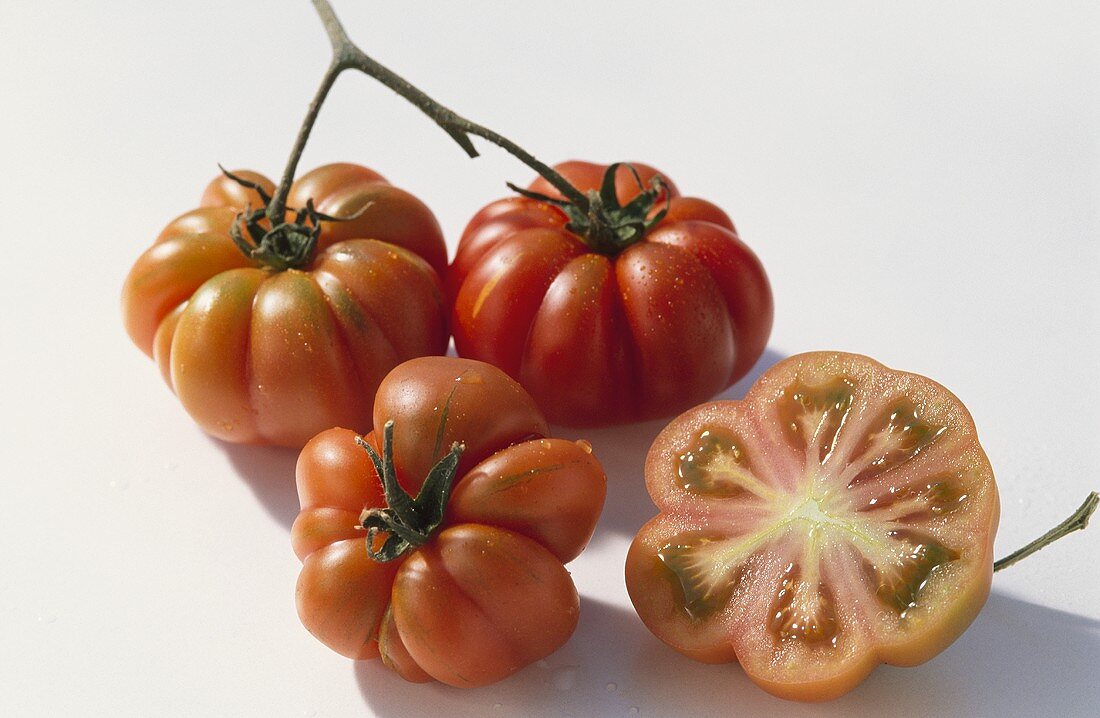 Drei ganze und eine halbe Fleischtomate