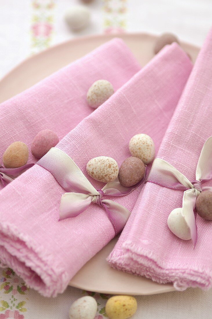Süsse Ostereier auf rosa Stoffservietten