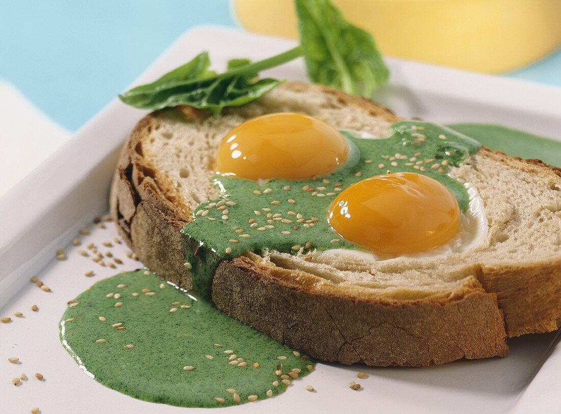 Slice of bread with fried eggs & spinach sauce