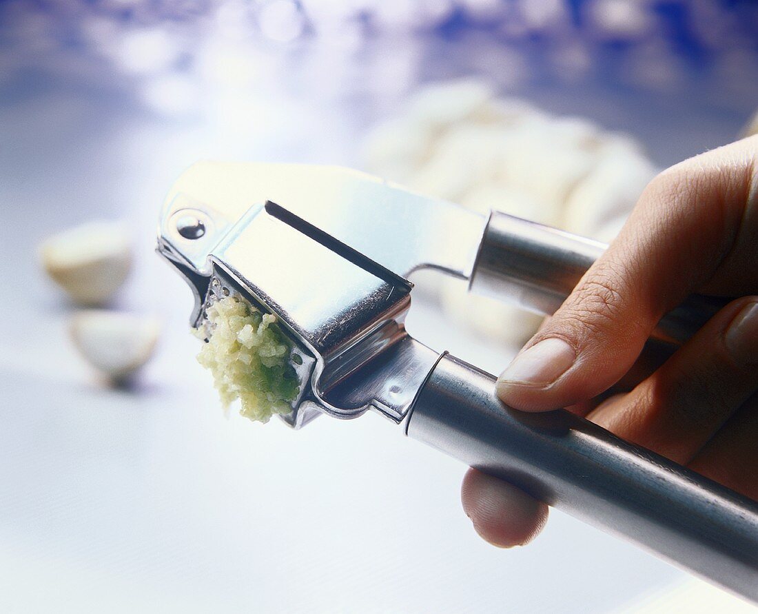 Pressing garlic through garlic press