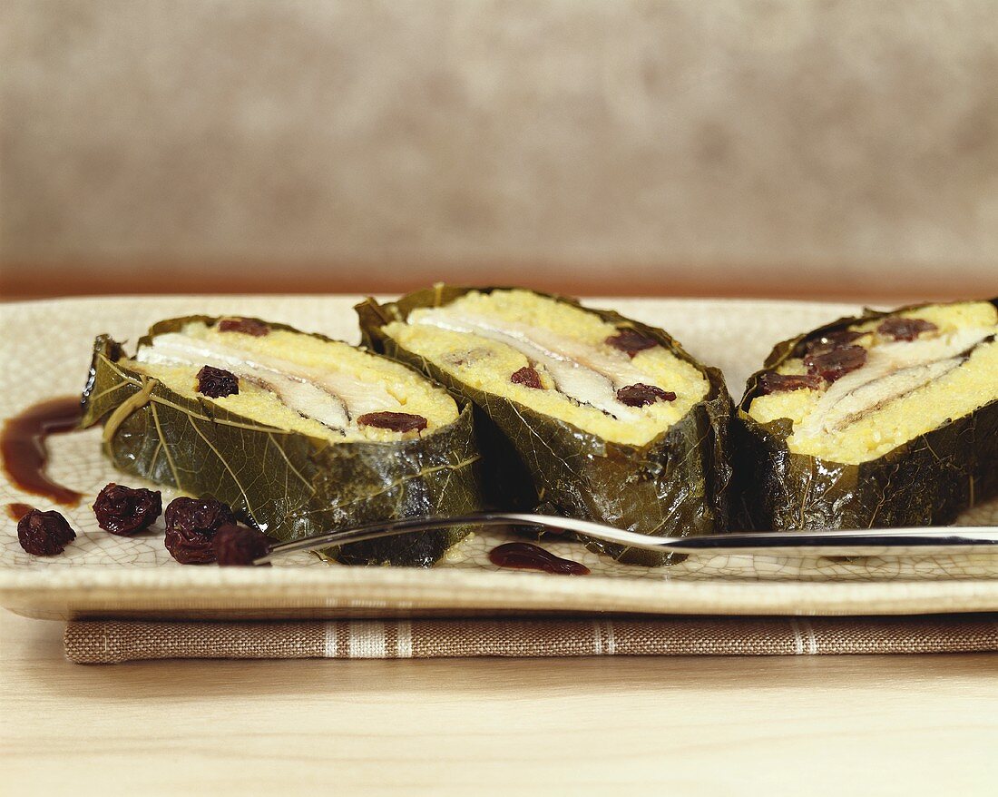 Trout and polenta roll in vine leaves