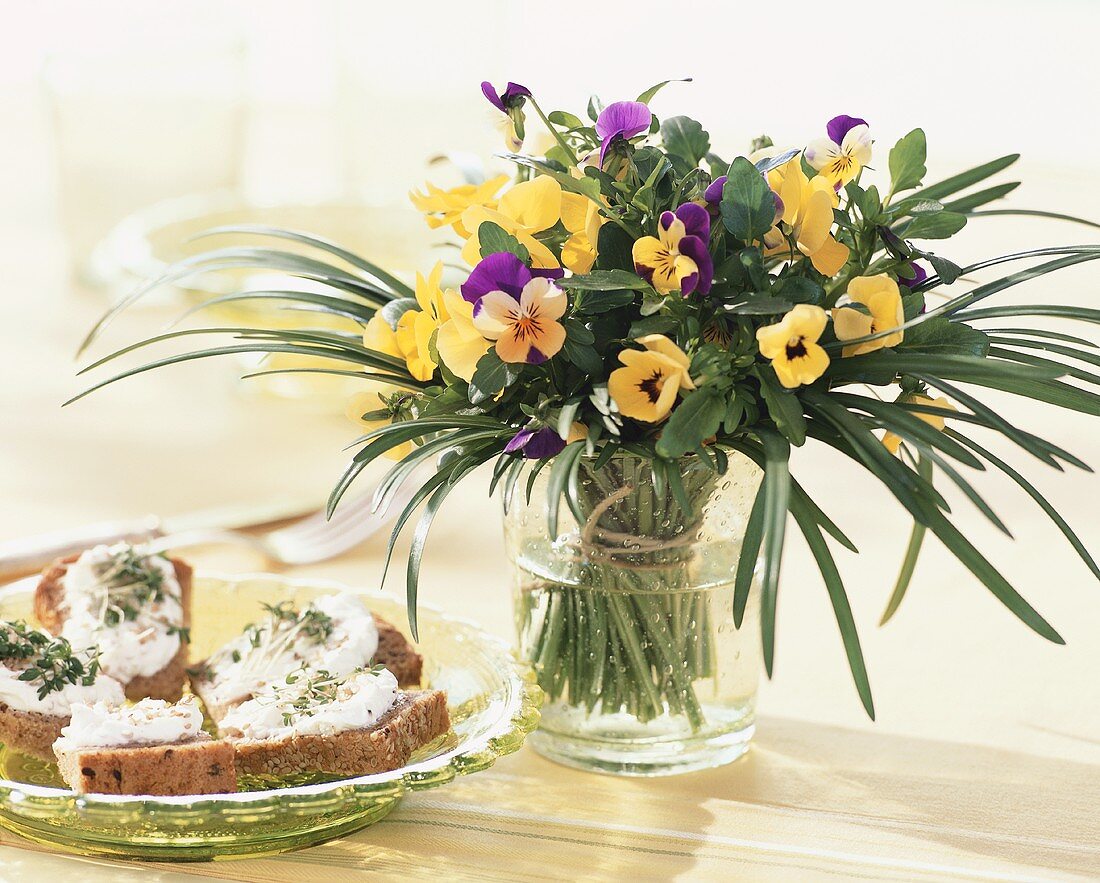 Cress and bread beside posy of horned violets
