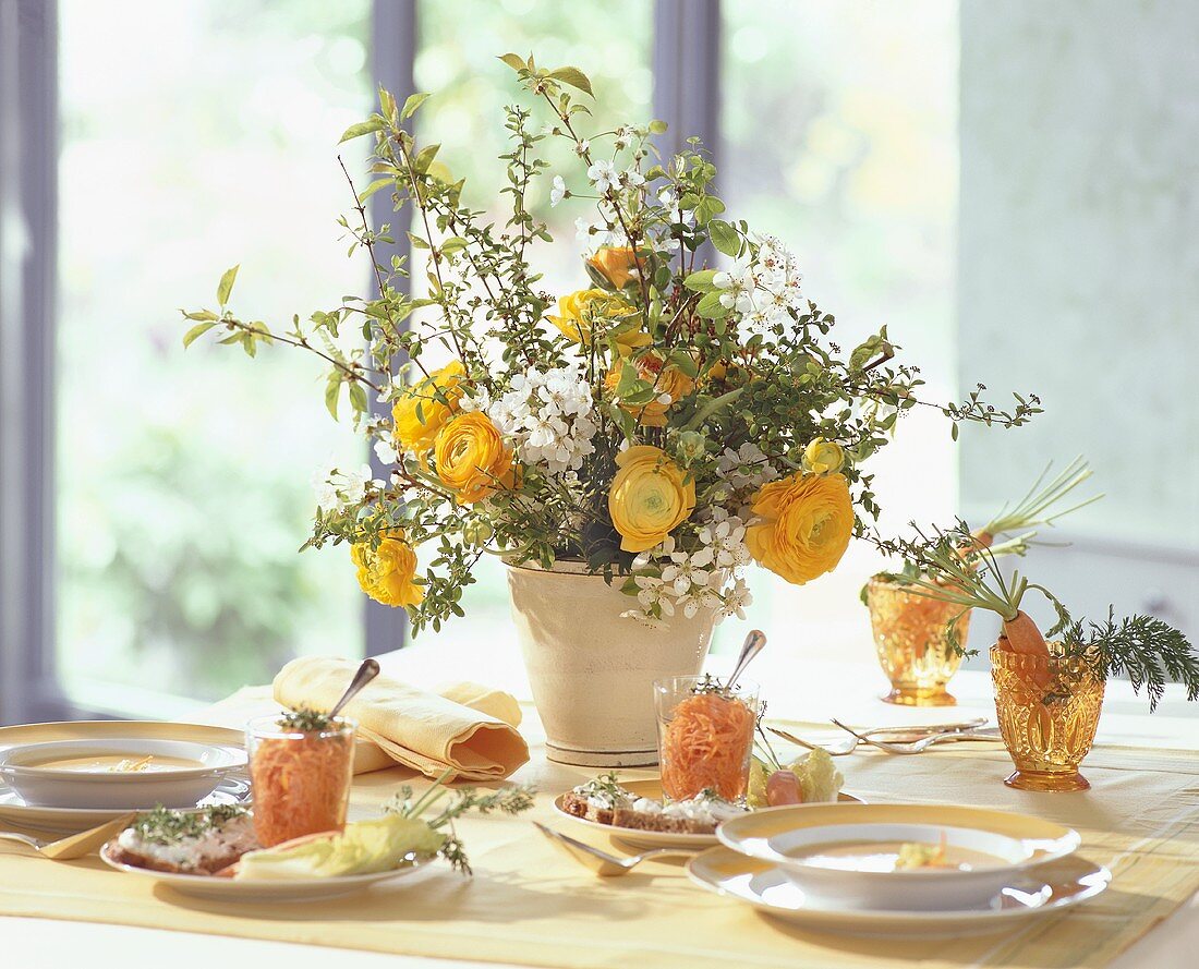 Gedeckter Tisch mit einem Frühlingsstrauss