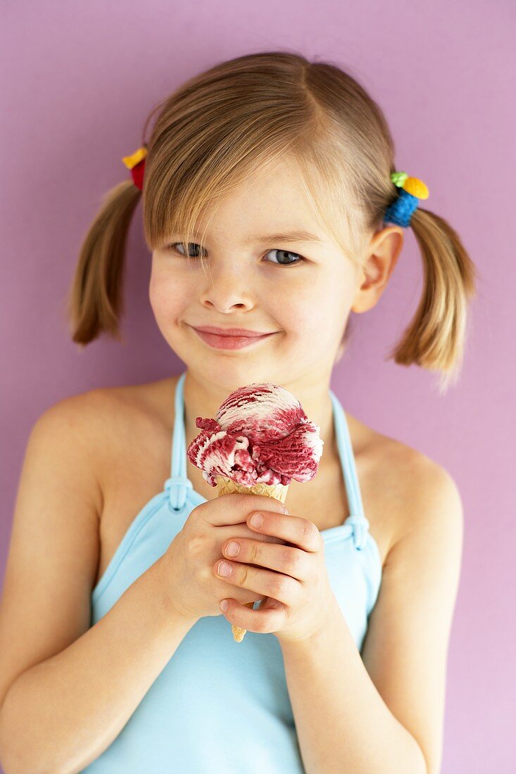 Kleines Mädchen hält Amarenakirsch-Eis mit zwei Händen