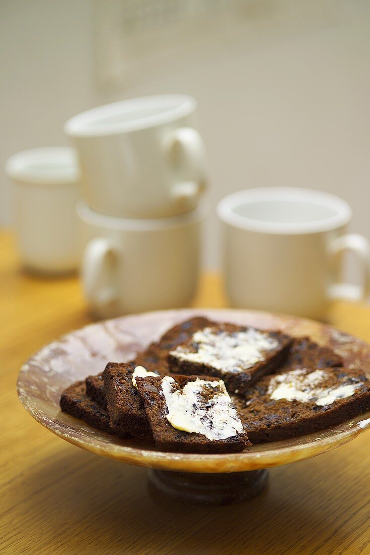 Gekochter Früchtekuchen in Scheiben mit Butter