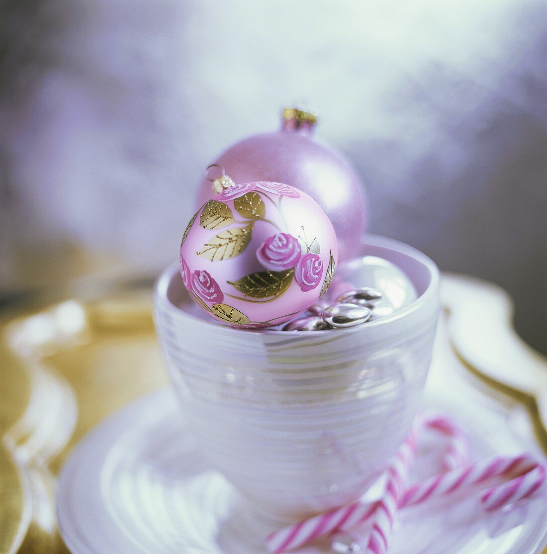 Schälchen mit Weihnachtskugeln und Zuckerstangen