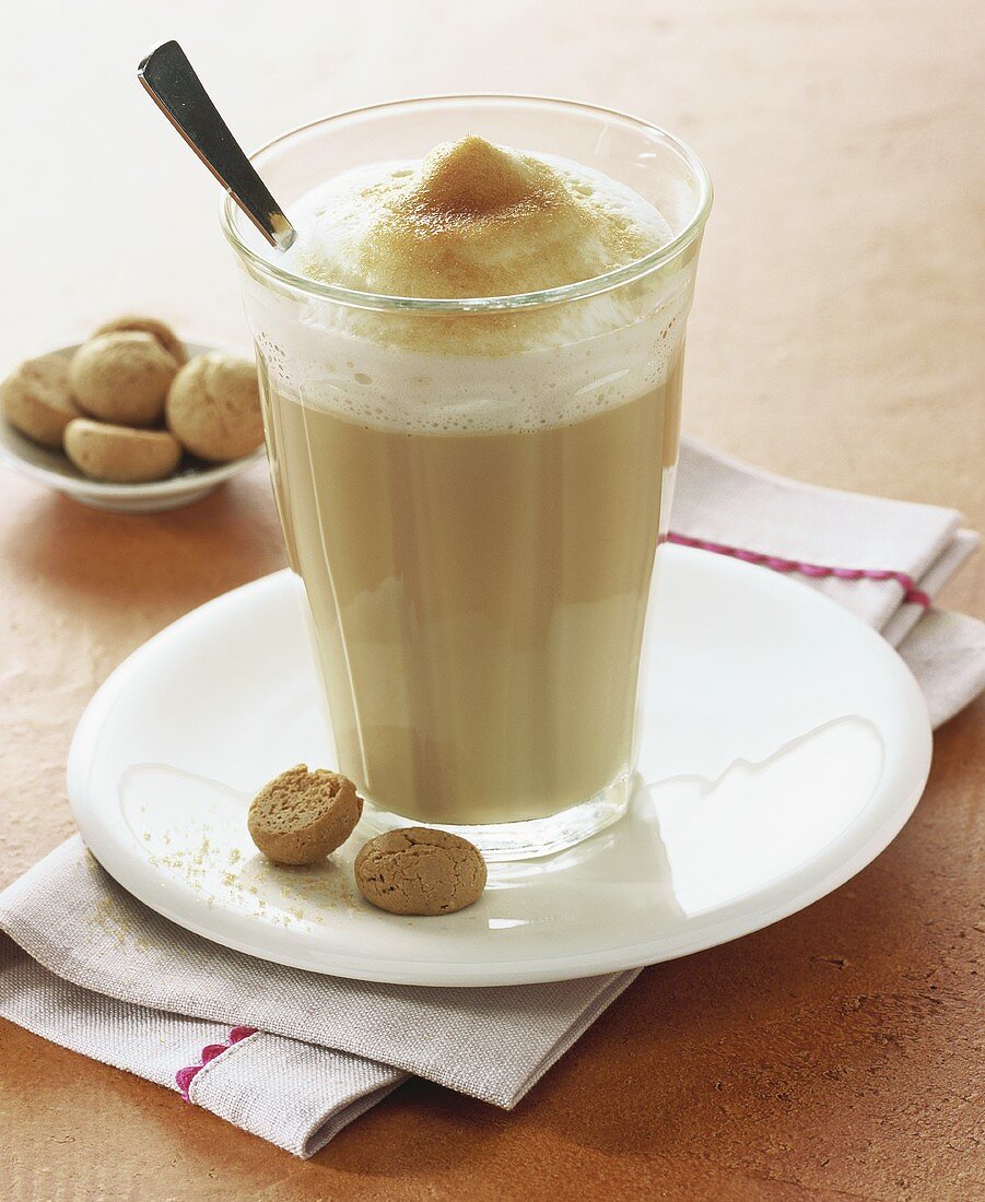 A glass of milky coffee with amaretti