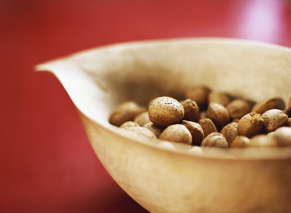 Unshelled almonds in a wooden bowl