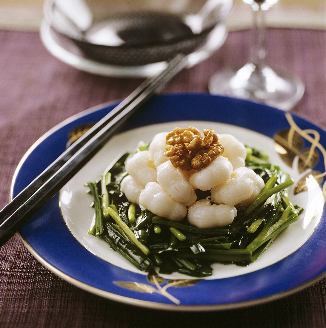 Shrimps and walnuts on green vegetables