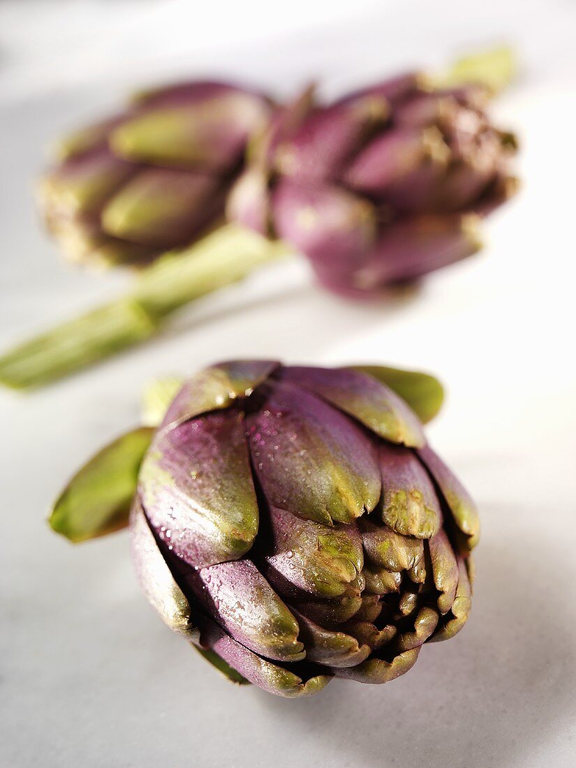 Three artichokes on white background