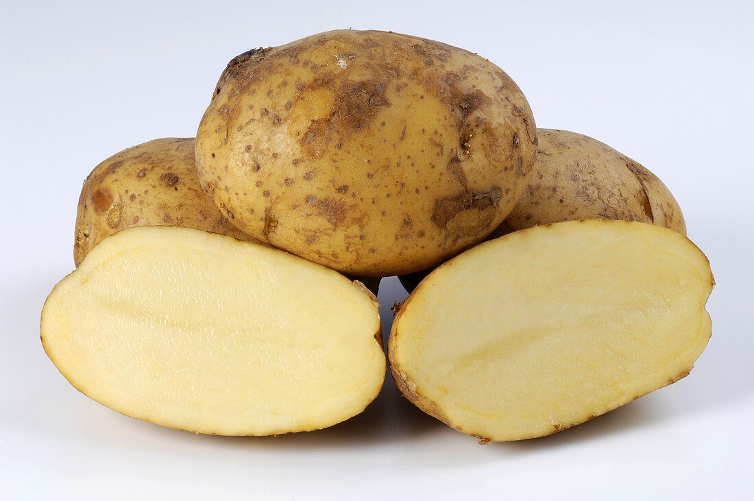 Several potatoes, variety 'Princess' whole and halved