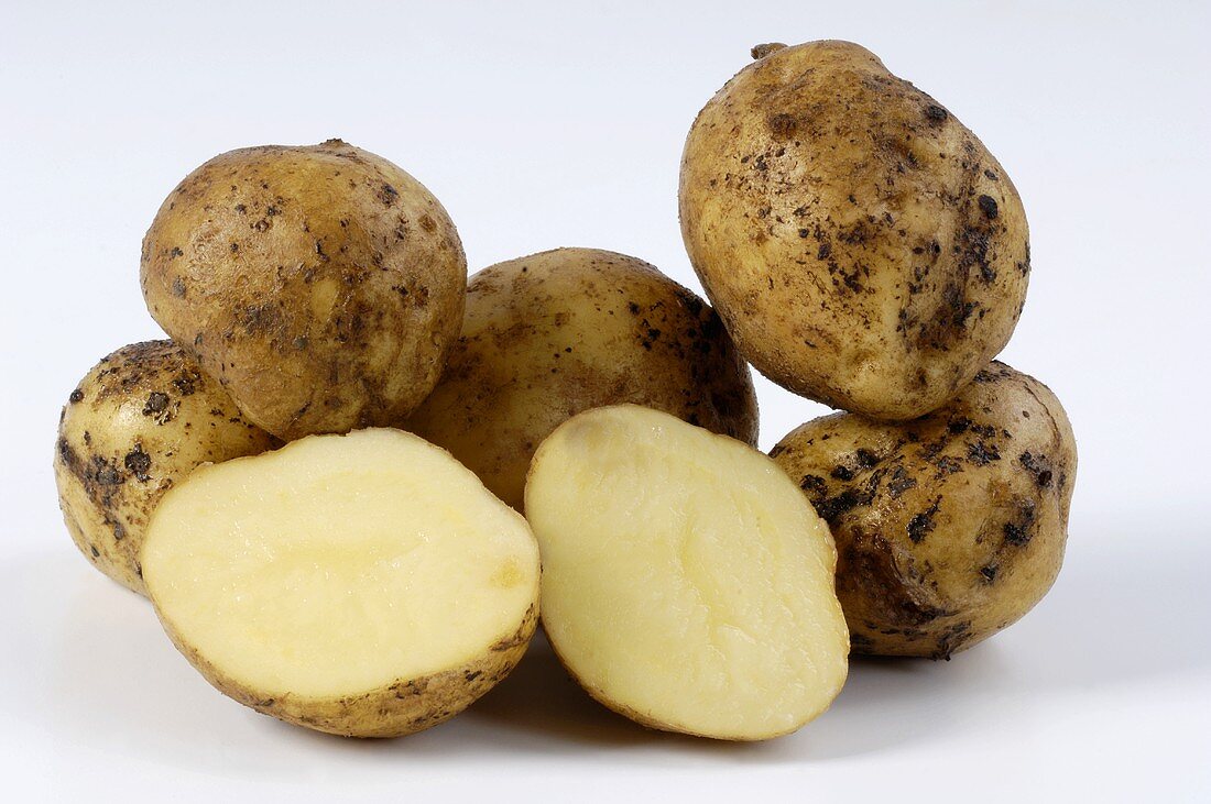 Several potatoes, variety 'Ackersegen', whole and half