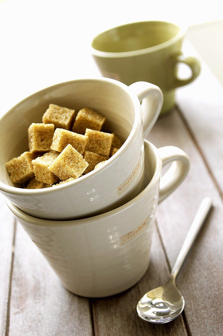 Three cups of coffee with sugar cubes