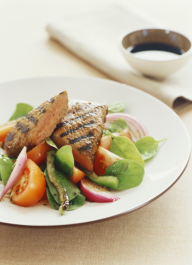 Grilled lamb steak on mixed salad