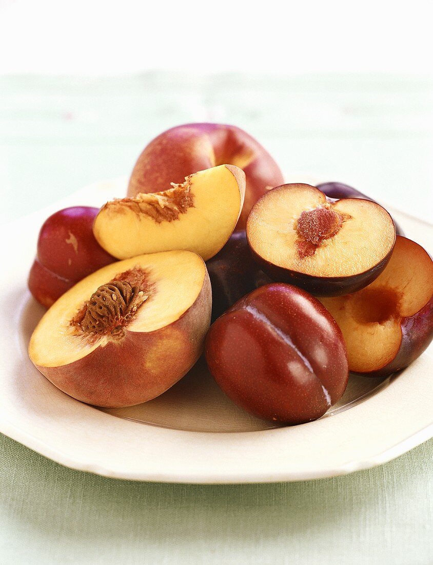 Several peaches and plums on a plate