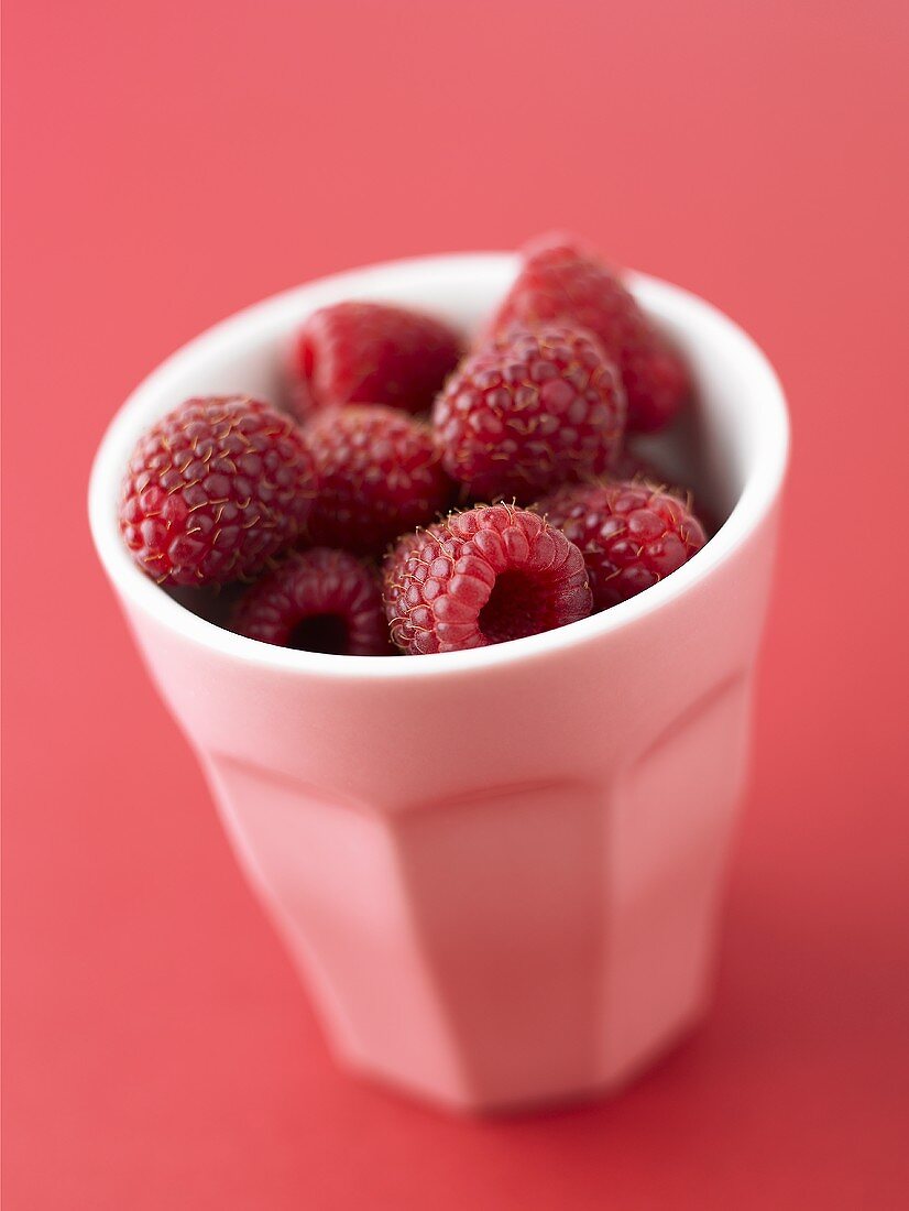Fresh raspberries in a pottery beaker