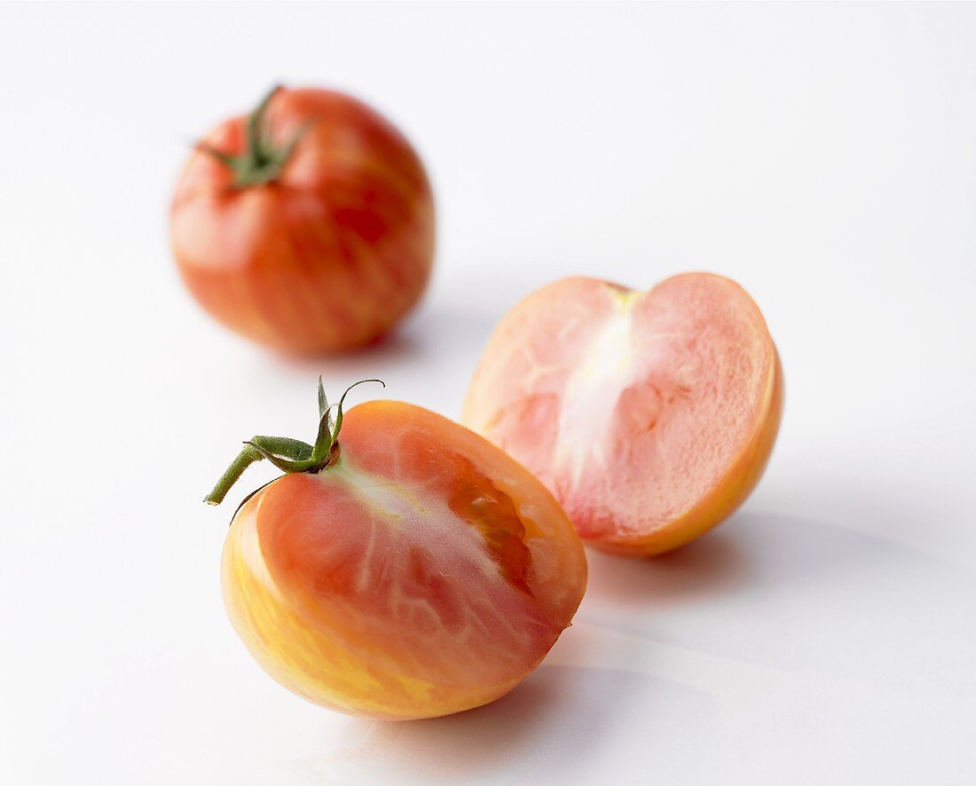 Two Tiger tomatoes, one halved