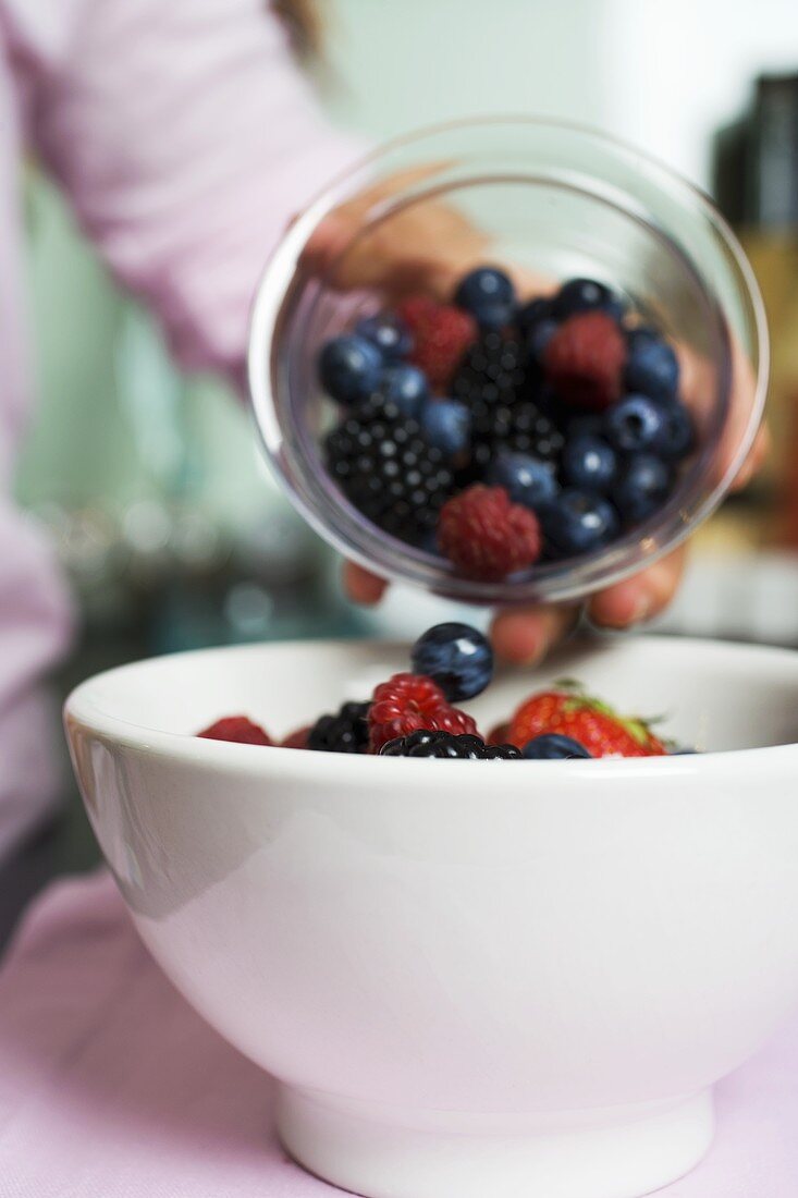 Tipping fresh berries into a bowl