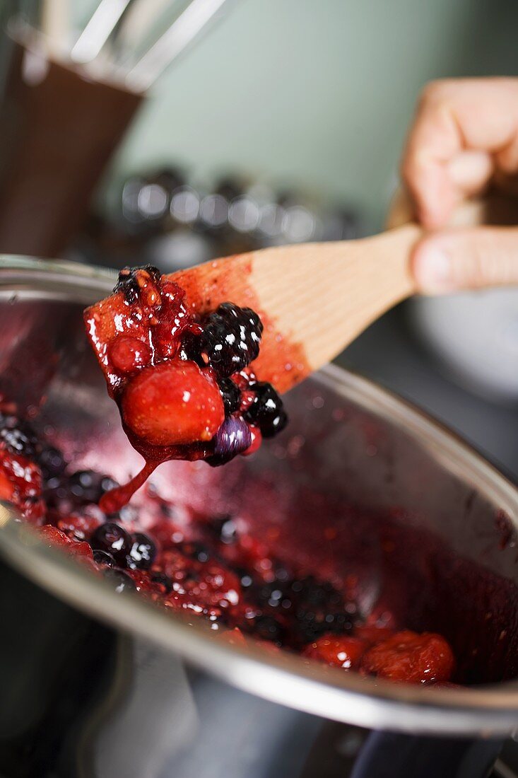 Berry jam, stirring the fruit and sugar