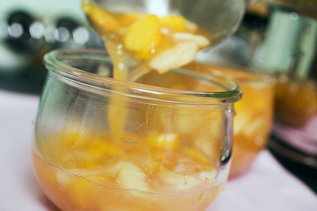 Aprikosenmarmelade in Gläser füllen