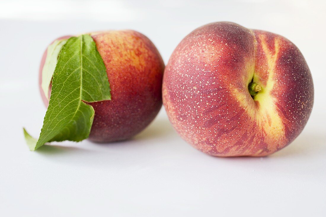 Zwei Pfirsiche mit Blatt