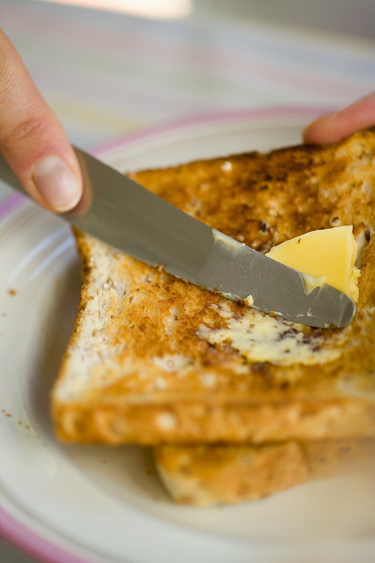 Toast mit Butter bestreichen