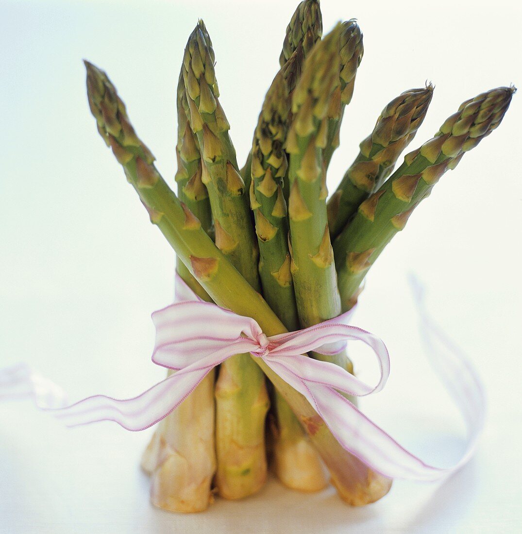 A bundle of green asparagus with pink bow
