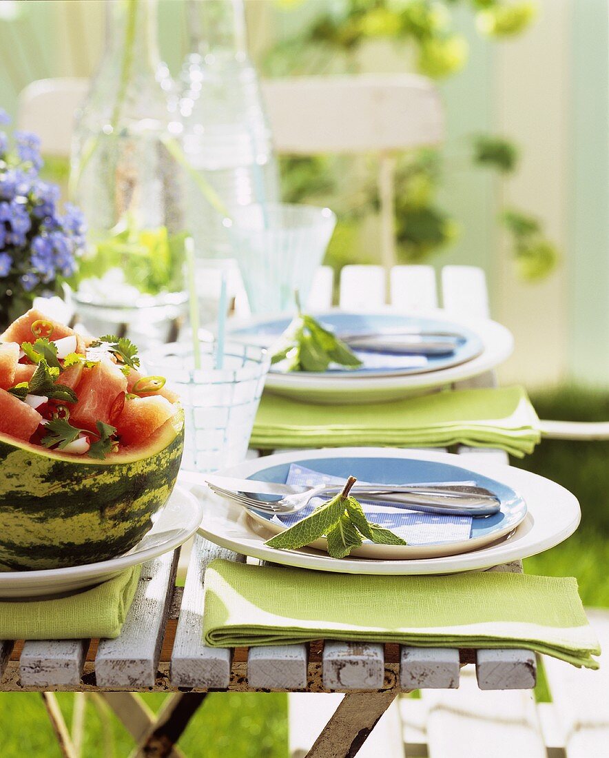 Gedeckter Tisch im Garten mit Melonensalat