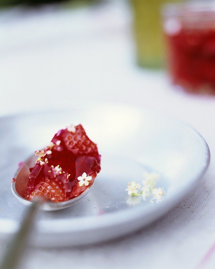 Erdbeer-Holunderblüten-Marmelade auf einem Löffel