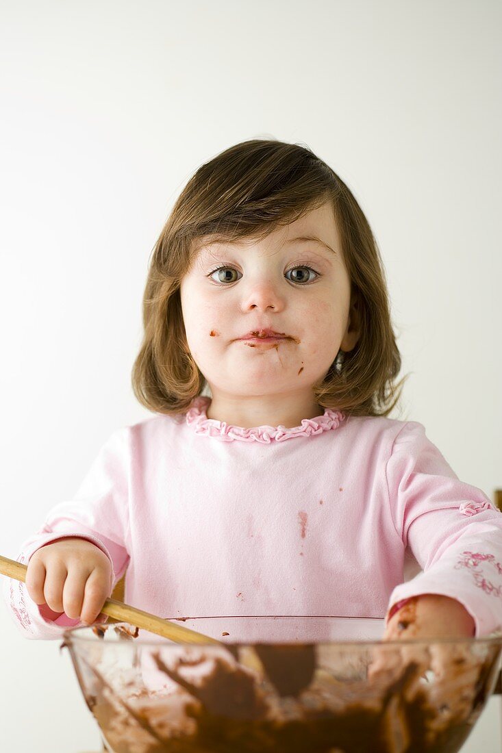 Small girl stirring cake mixture