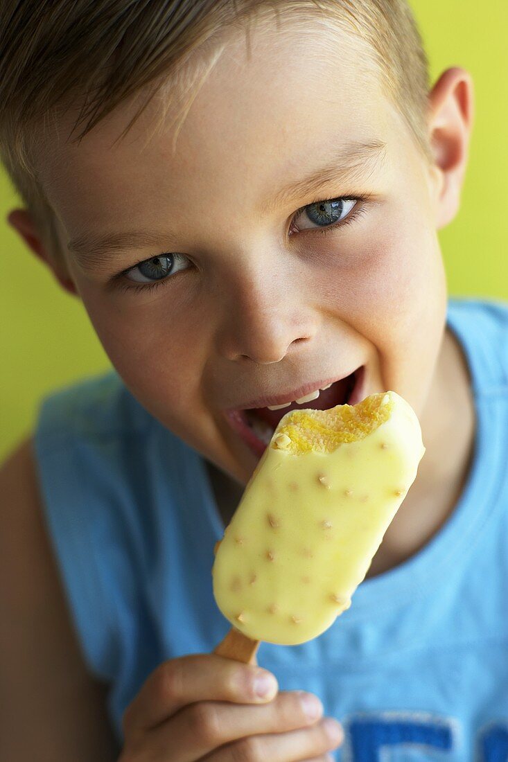 Junge isst ein Eis am Stiel