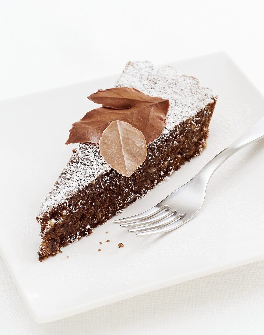 A piece of chocolate tart with chocolate leaves