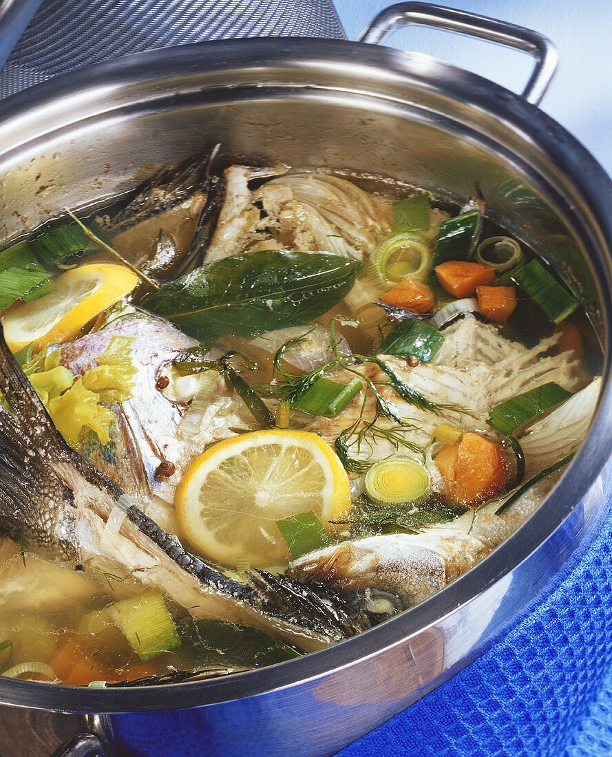 Fish stock with ingredients in pan