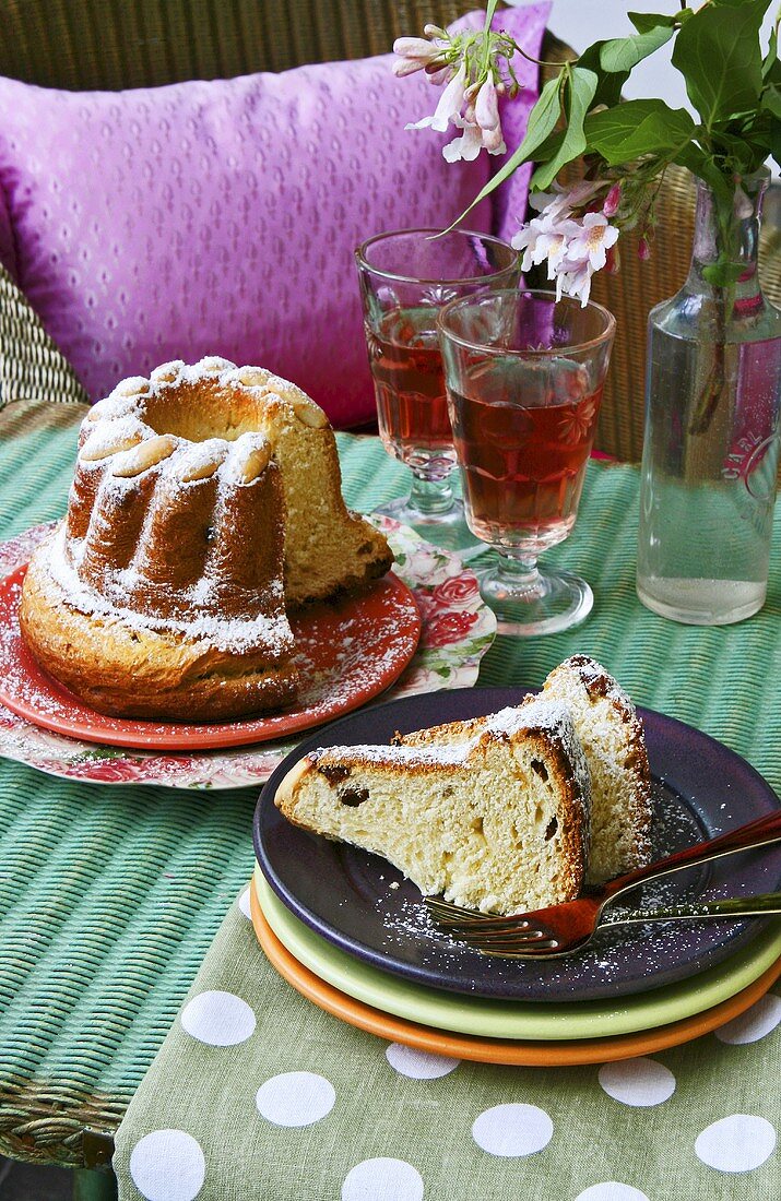 Gugelhupf, partly sliced, and plate with two pieces of cake
