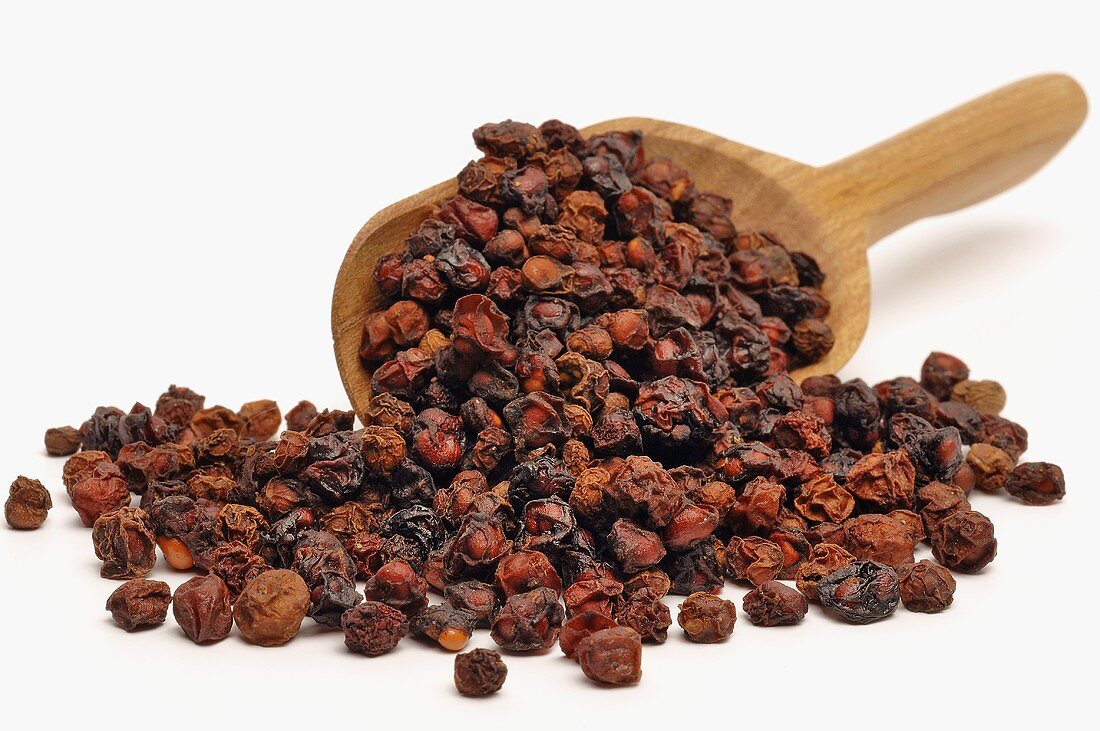 Dried Schisandra berries with a wooden scoop