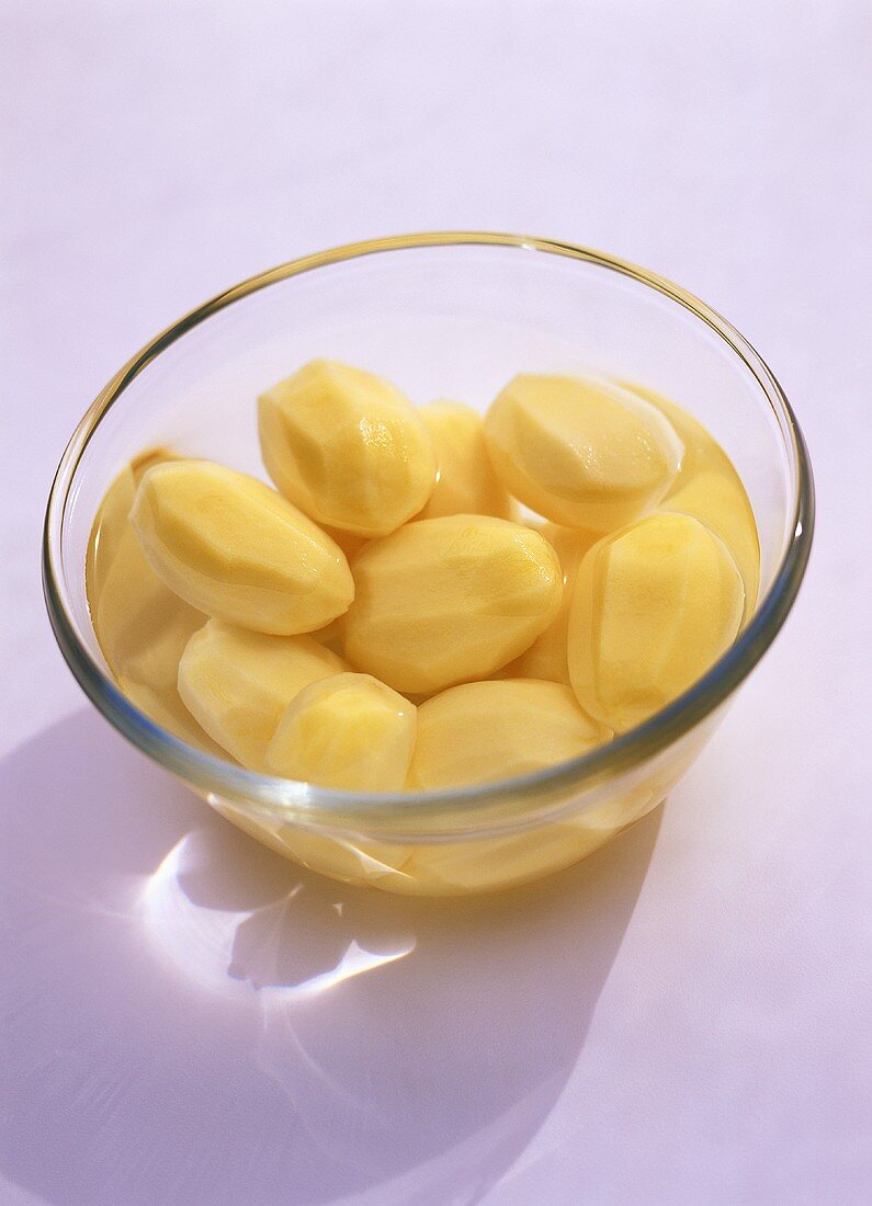 Peeled potatoes in a bowl of water