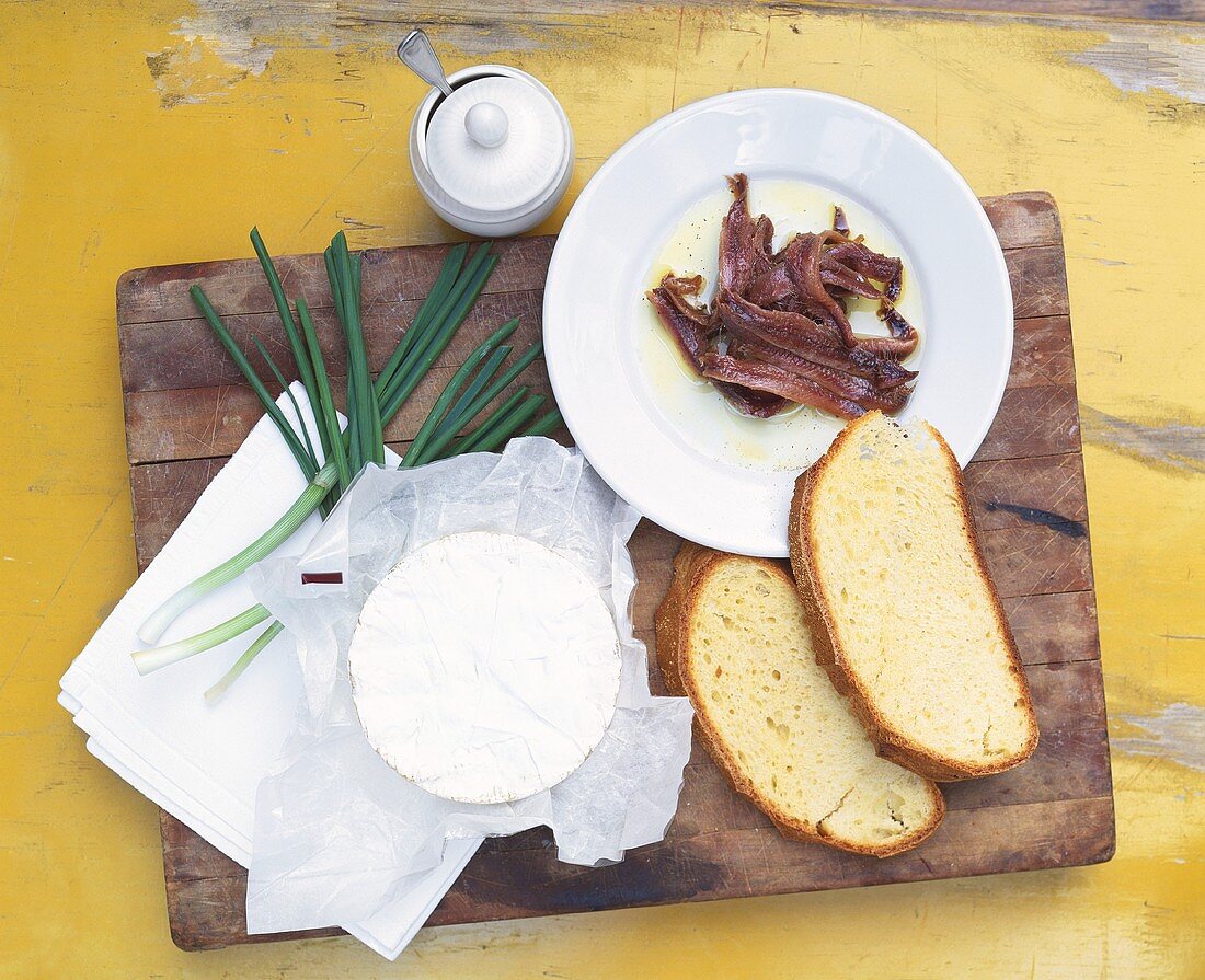 Camembert, slices of bread, anchovies and spring onions
