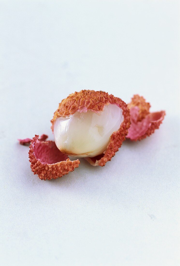 A partly peeled lychee
