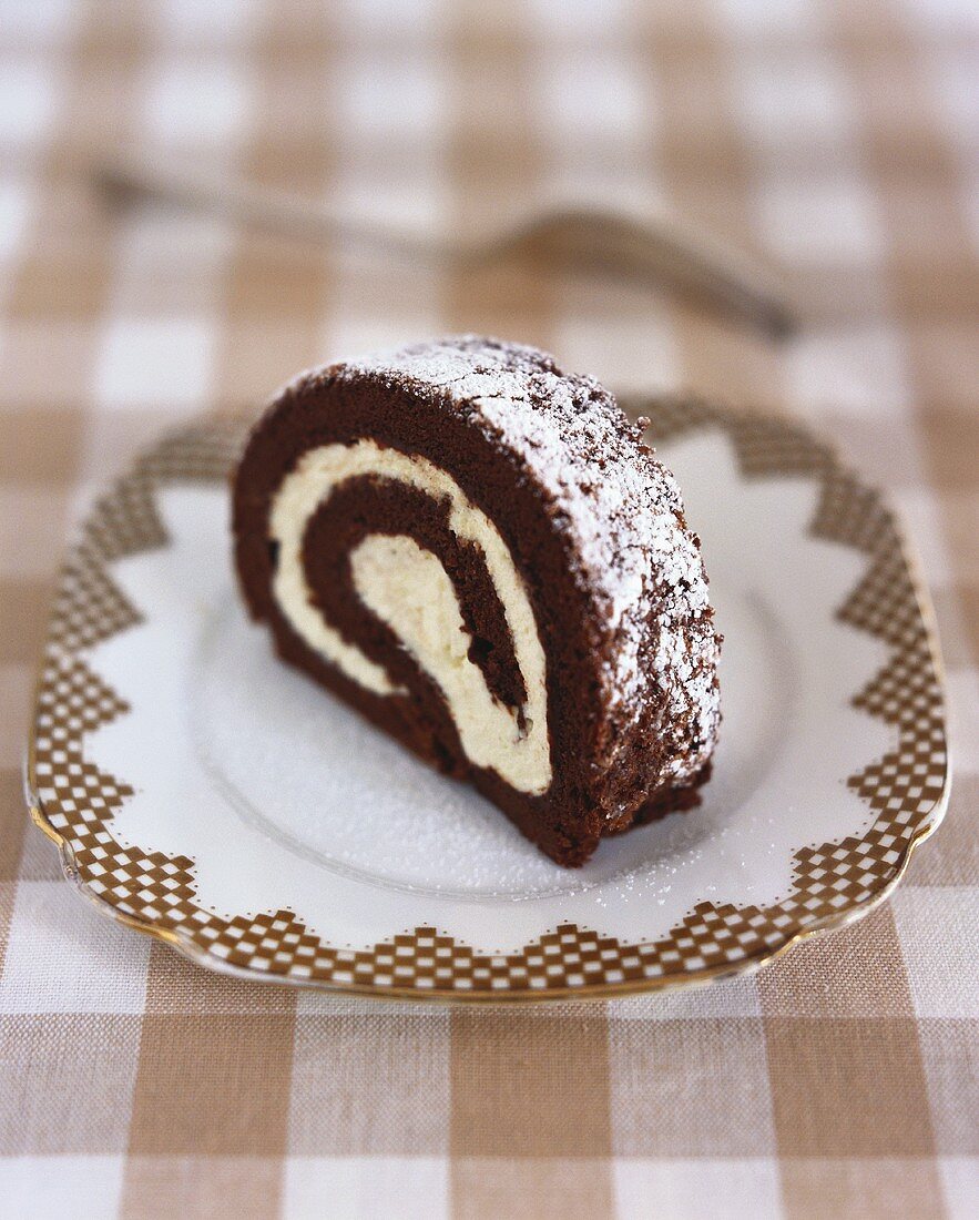 A slice of cream-filled chocolate Swiss roll