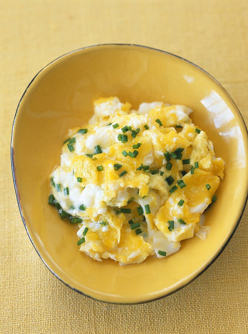 Scrambled eggs with chives in a bowl