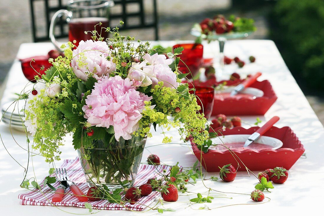 Vase of peonies, wild strawberries and lady's mantle