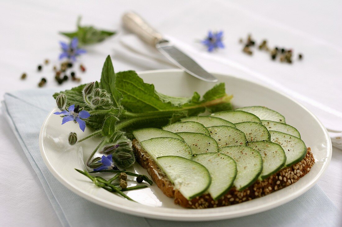 Open cucumber sandwich with black pepper, borage & rosemary