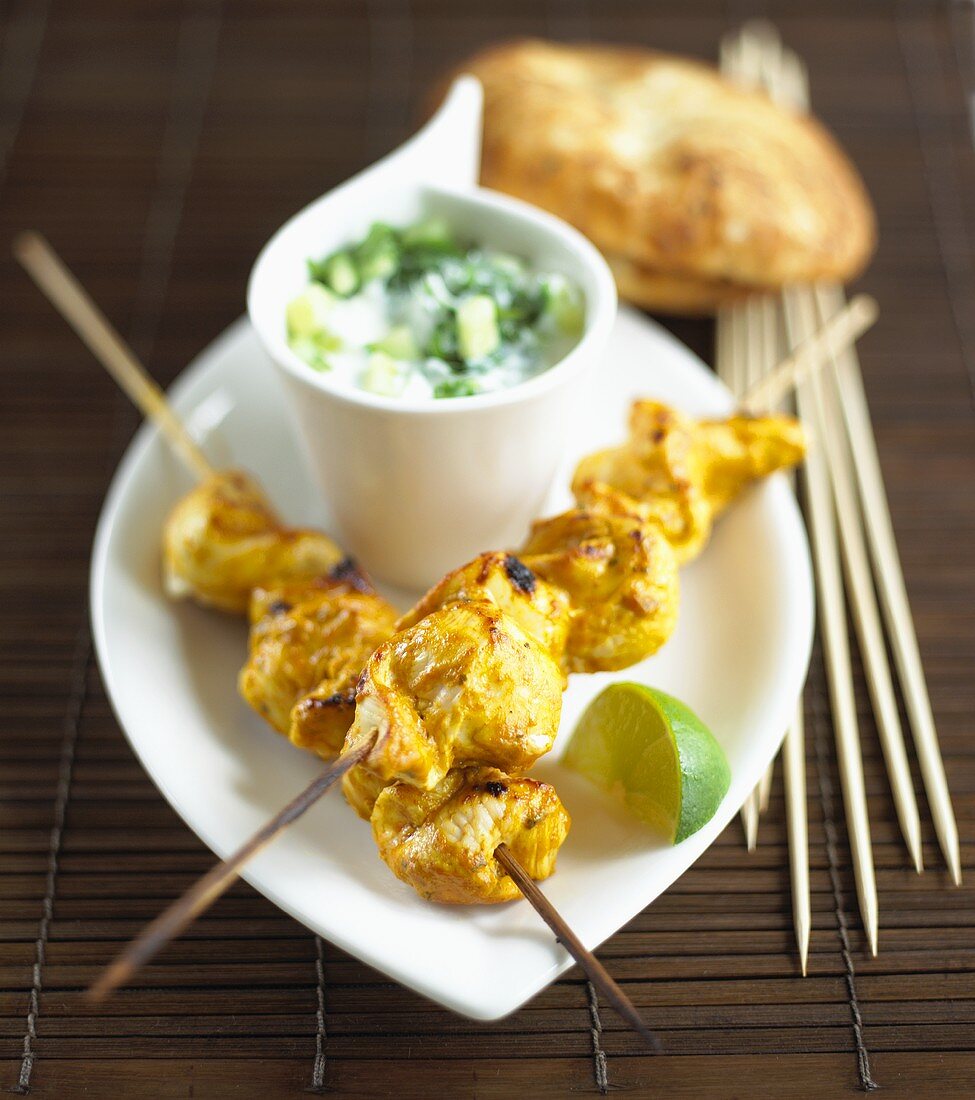 Chicken kebabs with raita and naan bread